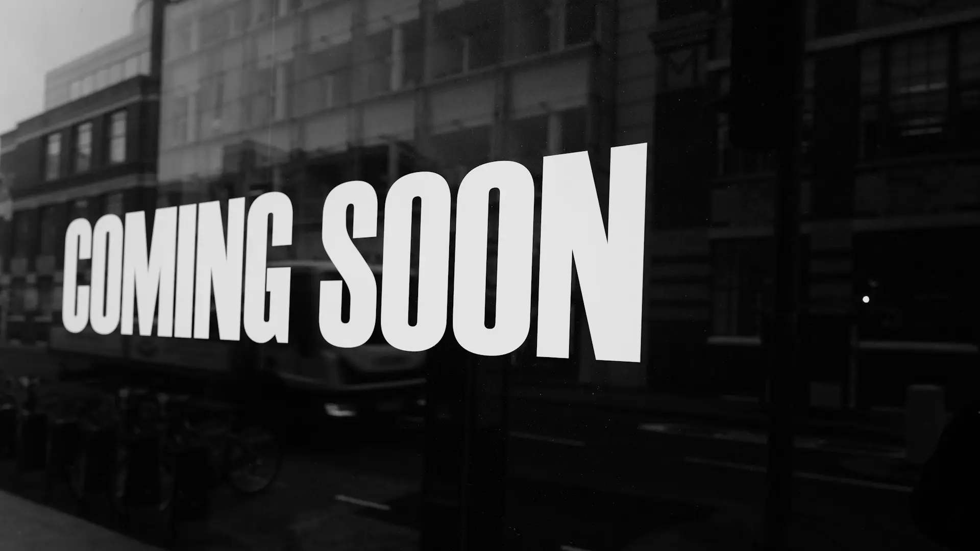 a black and white photo of a sign that says coming soon